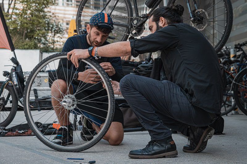 Un réparateur de vélo explique comment changer son pneu à un client