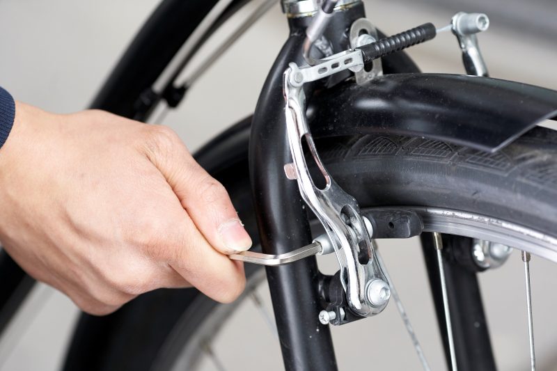 Un réparateur change des patins de frein de vélo