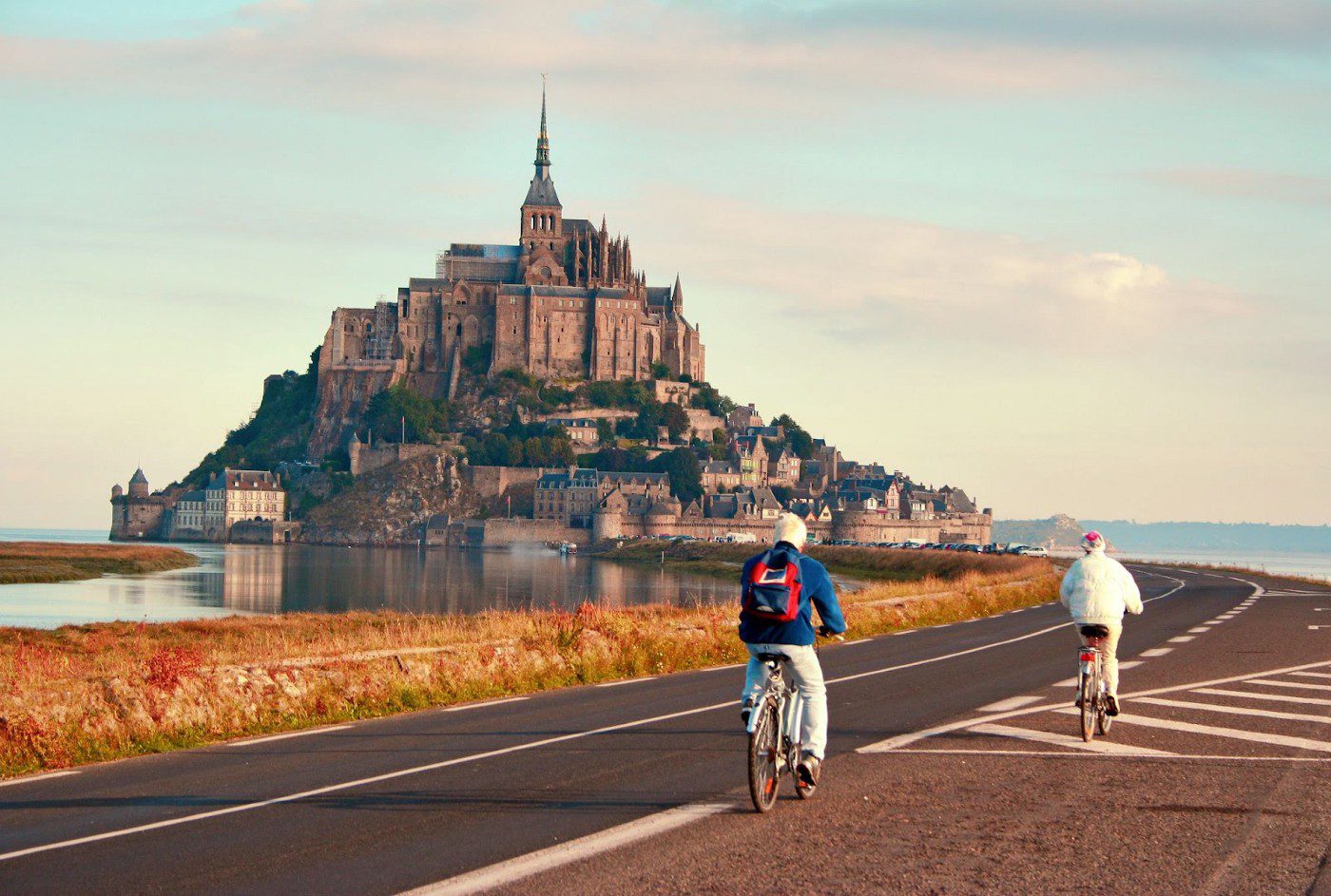 2 personnes aux abords du Mont St Michel à vélo